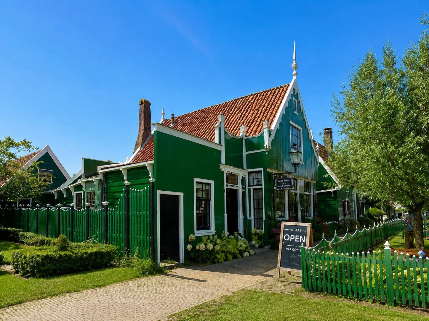 Traditional windmills and green wooden houses beside the Zaan river at Zaanse Schans