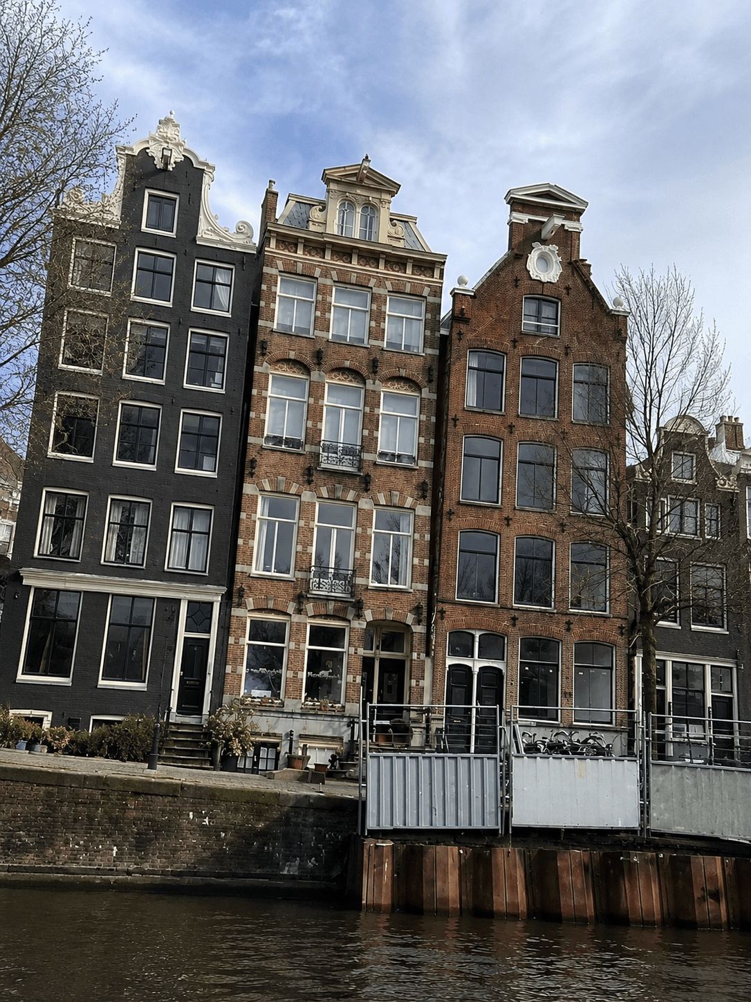 Amsterdam Canal House Facades From the Water Three adjoining Amsterdam canal house facades seen from a boat on the water