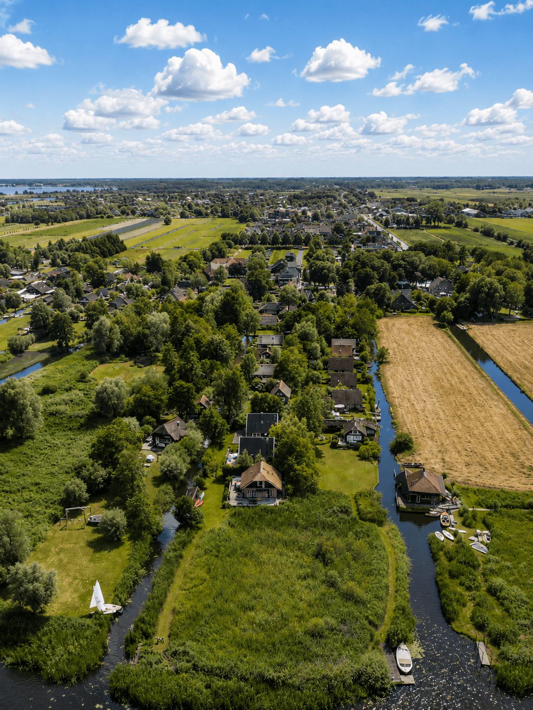 Aerial view of a canal-side village near Giethoorn surrounded by green polder fields