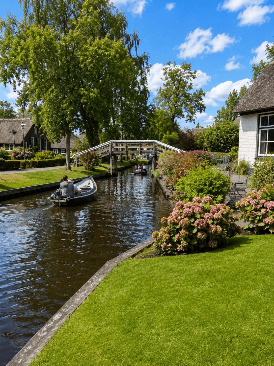 Giethoorn canal with punt boats bordered by blooming hydrangea bushes and a thatched house
