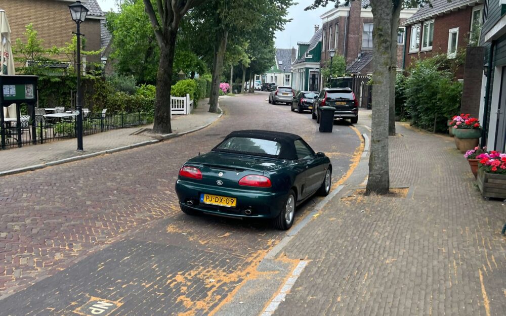 Brick-paved Lagedijk street with traditional houses in Zaandijk