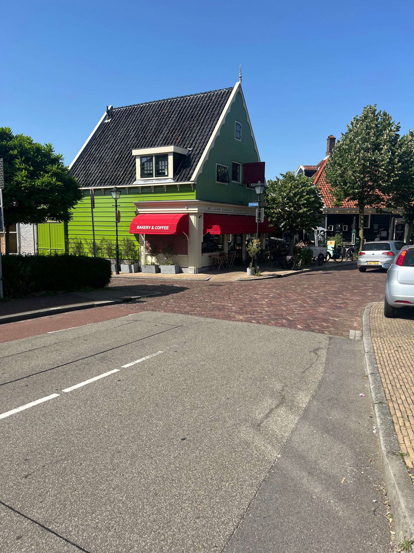 Bright green traditional wooden house with a bakery and coffee shop on a Zaandijk street corner
